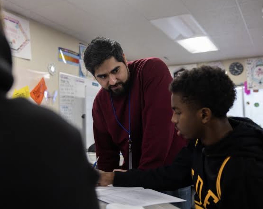 A mentor working one-on-one with a student at a desk